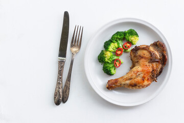 Healthy food grilled chicken has broccoli vegetable in plate on white wood table.