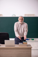 Old male teacher in the classroom