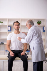 Obraz premium Young male patient visiting old male doctor