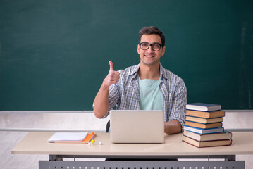 Young male student sitting in the classroom