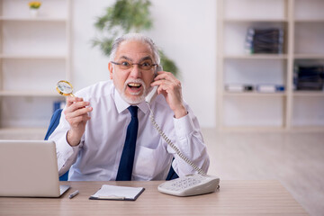 Old male boss working at workplace
