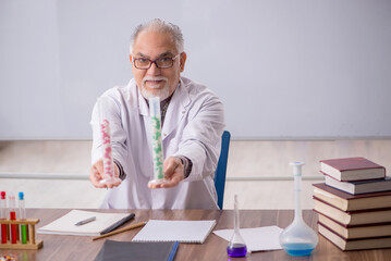 Old male teacher chemist sitting in the classroom