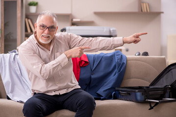 Fototapeta premium Old man preparing for trip at home