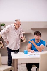 Obraz premium Young male student and his grandfather at home