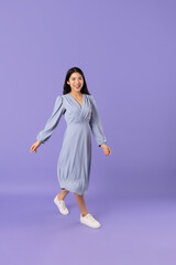 Asian girl in blue dress on purple background