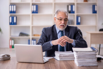 Old male employee working in the office