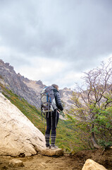 mujer mira el paisaje luego de hacer trakking y subir una montaña