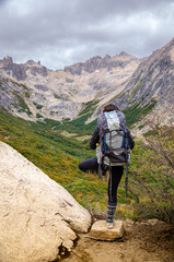 mujer hace pose de yoga en la cima de una montaña luego de terminar un trakkin