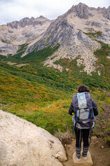 mujer mira el paisaje luego de hacer trakking y subir una montaña