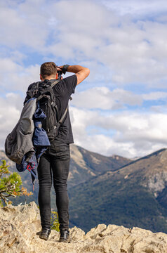 fot&oacute;grafo en la cima de una monta&ntilde;a sacando fotos del paisaje