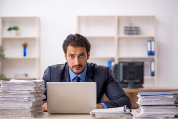 Young male employee and too much work in the office