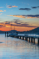 Fototapeta premium Sunrise waterscape with boats and clouds