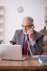 Old male boss employee working in the office