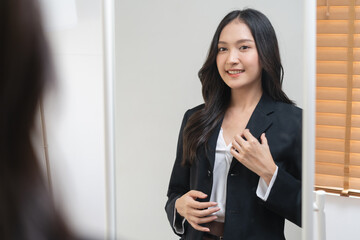 Obraz premium Confidence before get interview in the first jobber, Young woman looks at the mirror and practicing talking to herself preparing to interview job.