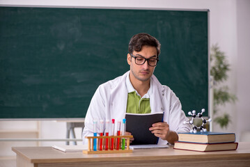 Young male chemist in the classroom