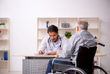 Old man in wheelchair visiting young male doctor