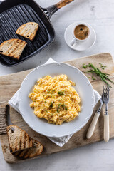 Top view of traditional breakfast with scrambled eggs, bread toasts and coffee