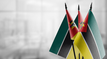 Small flags of the Mozambique on an abstract blurry background