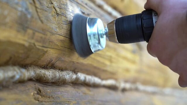 carpenter grinds old paint on wood
