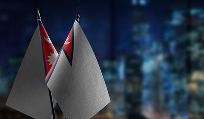 Small flags of the Nepal on an abstract blurry background