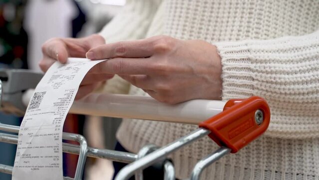 the girl looks at the receipt from purchases