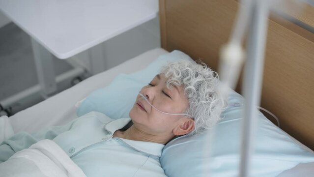 ベッドで眠る高齢者　入院患者　寝たきり老人