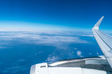 View of the blue sky and fluffy clouds from the window of the plane.