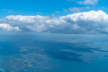 A view of the blue sky and fluffy clouds, a picture taken from the window of an airplane.