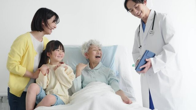 高齢の入院患者と家族に説明する医師