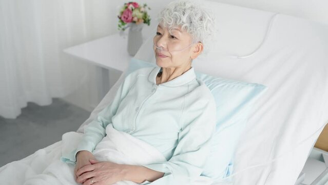 電動介護ベッドに寝るシニア女性