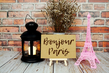 Bonjour Paris text message write on paper card with pink Eiffel tower souvenir and flower blooming © may1985