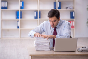 Young male employee and too much work in the office