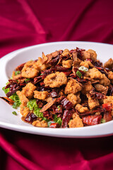 wok fried chicken cube meat with spicy hot dry chilli in Szechuan style on red white cloth asian chinese banquet halal menu