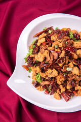 wok fried chicken cube meat with spicy hot dry chilli in Szechuan style on red white cloth asian chinese banquet halal menu