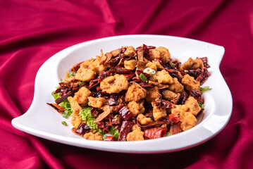 wok fried chicken cube meat with spicy hot dry chilli in Szechuan style in plate on wood table asian chinese halal food banquet menu for restaurant