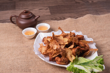 deep fried crispy golden chicken meat with ginger slices and garlic on wood table chinese tea pot asian halal banquet menu