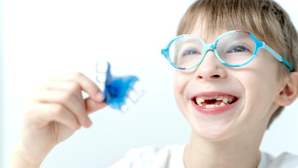 a boy with a tooth alignment plate in his hand