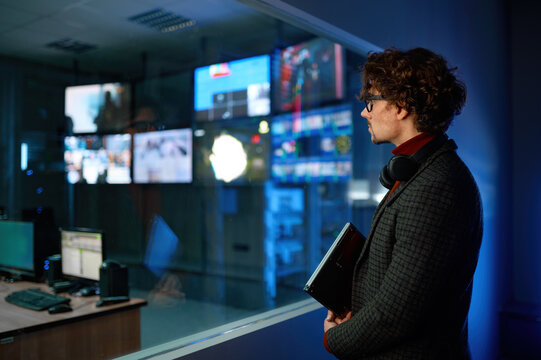 Man looking at computer screen reflection in server room window