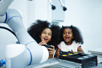 Cheerful ingenious girl holding a remote control while testing his engineering wonder with education learning technology science robotics mechanics classes intelligent smart,