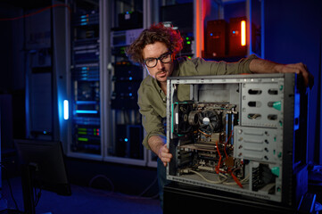 Fototapeta na wymiar Repairman working with computer system unit at PC repair service center