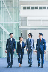 オフィスの廊下を歩くビジネスマンの男女