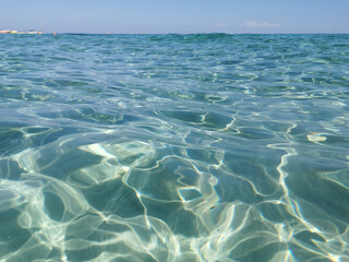 Crystal clear, blue, transparent water of the Mediterranean Sea on Sunrise beach.