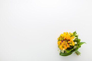 Beautiful fresh yellow freesia flower bouquet on white table background. Closeup. Empty place for inspirational text, lovely quote or positive sayings. Top down view.