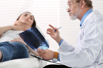 Obraz premium Orthopedist showing X-ray picture to patient in clinic