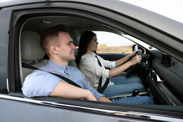 Happy young couple travelling together by car