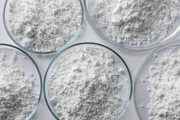Petri dishes with calcium carbonate powder on white table, flat lay