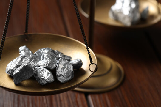 Vintage scales with silver nuggets on wooden table, closeup