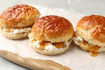 Freshly baked soda water scones with apricot jam and butter on table, closeup