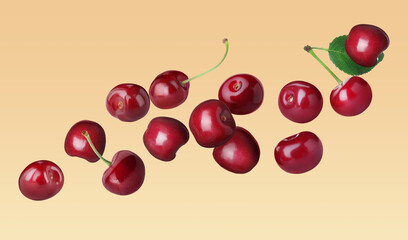 Fresh cherries flying on pale orange background