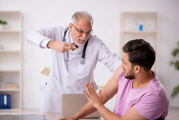 Young male patient visiting old male doctor